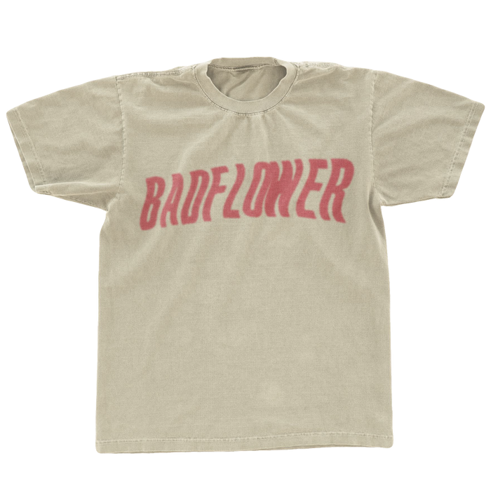 Tan tee shirt with Badflower written in red across the front