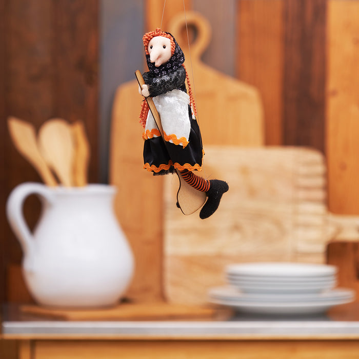 A Black & Orange Kitchen Witch Figurine.
