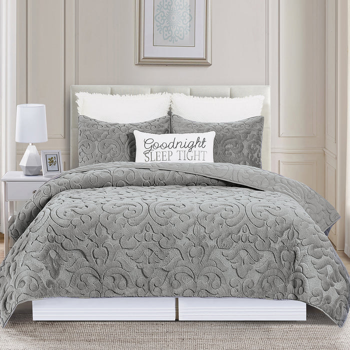 A Cornelia Quilt Set displayed on a made bed.