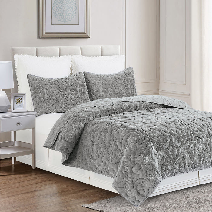 A Cornelia Quilt Set displayed on a made bed.