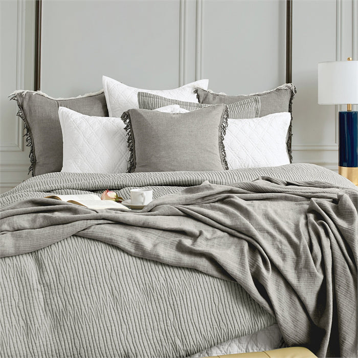 A Declan Ash Bed Throw displayed on a bed.
