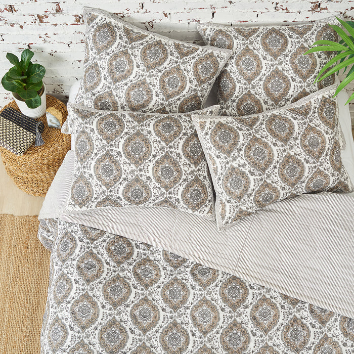 A freddie quilt displayed on a made bed.