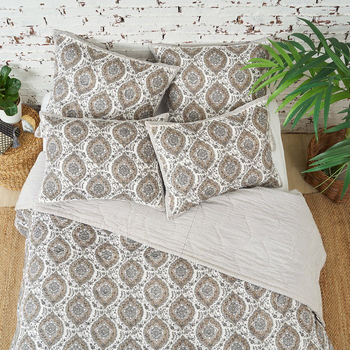 A freddie quilt displayed on a made bed.