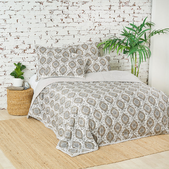A freddie quilt displayed on a made bed.