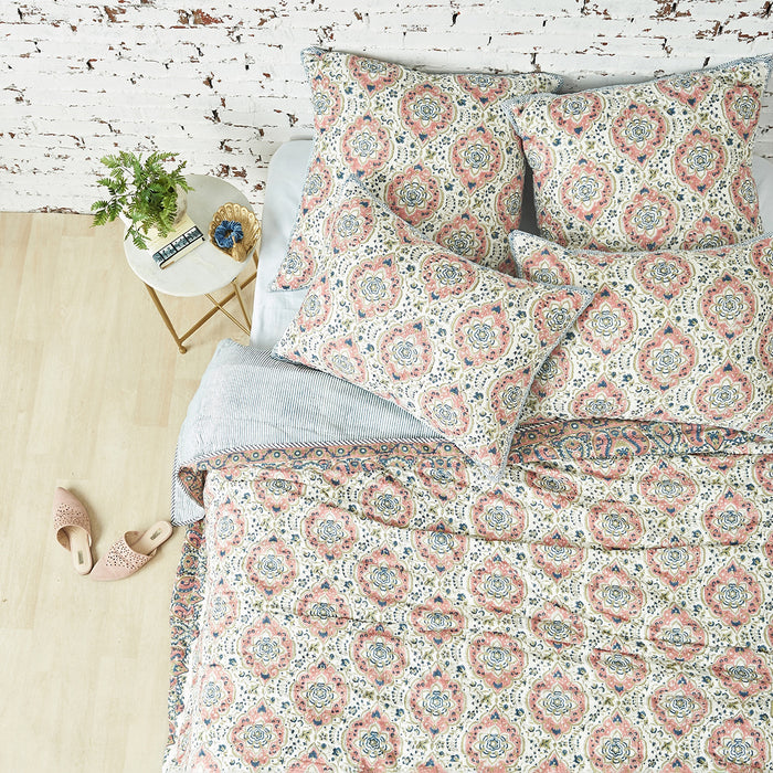 A freddie quilt displayed on a made bed.