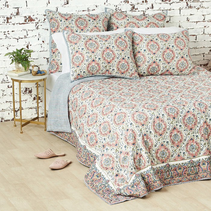 A freddie quilt displayed on a made bed.