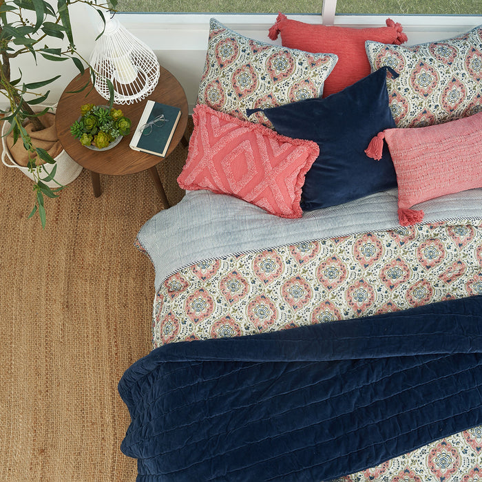 A freddie quilt displayed on a made bed.