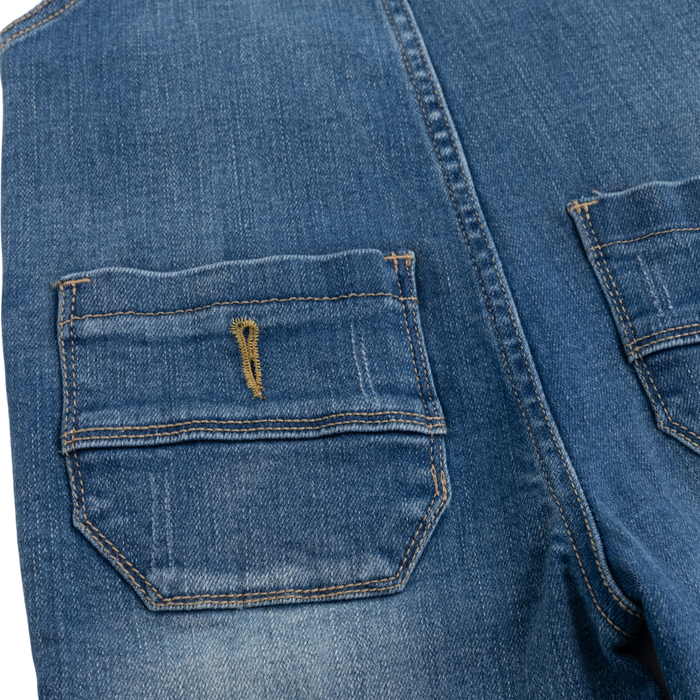 Close-up of blue denim jeans showing a front patch pocket with contrast stitching and a small yellow embroidered detail.