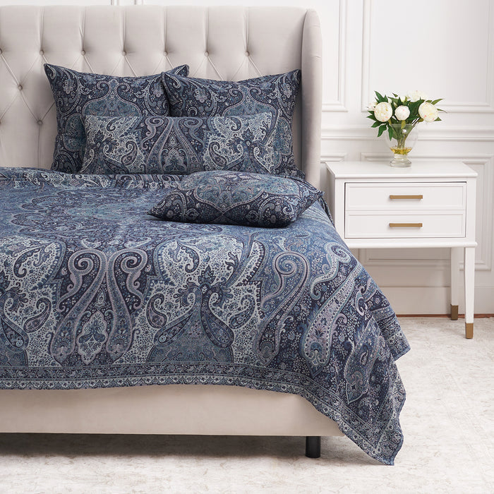 A Suman Coverlet displayed on a bed.