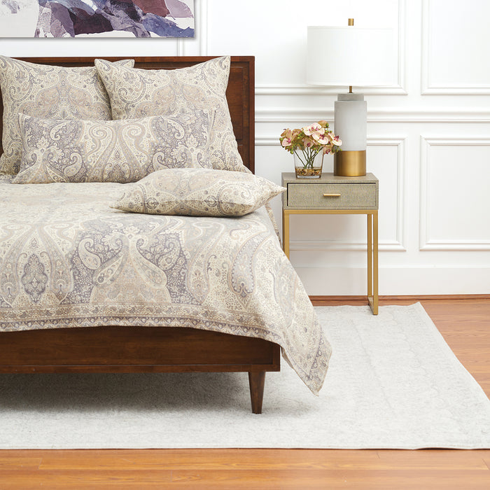 A Suman Coverlet displayed on a bed.