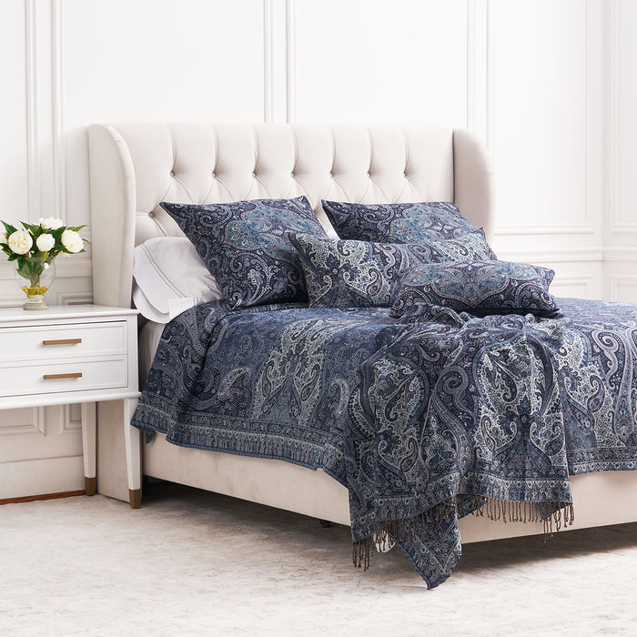 A Suman Coverlet displayed on a bed.