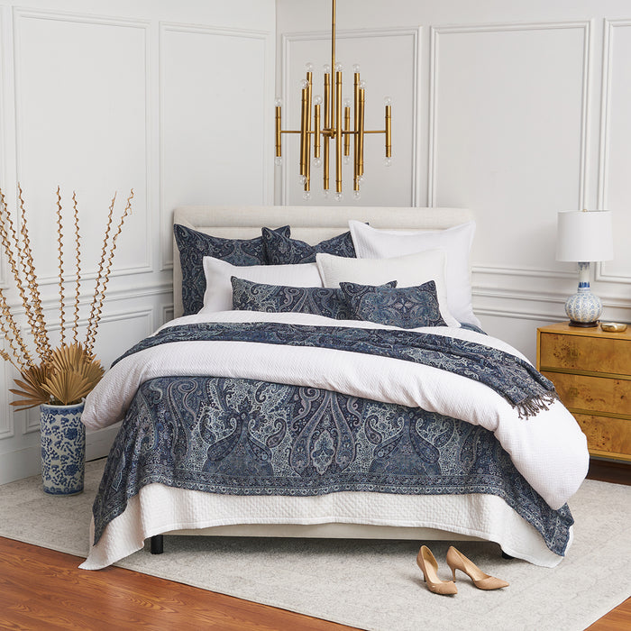 A Suman Coverlet displayed on a bed.