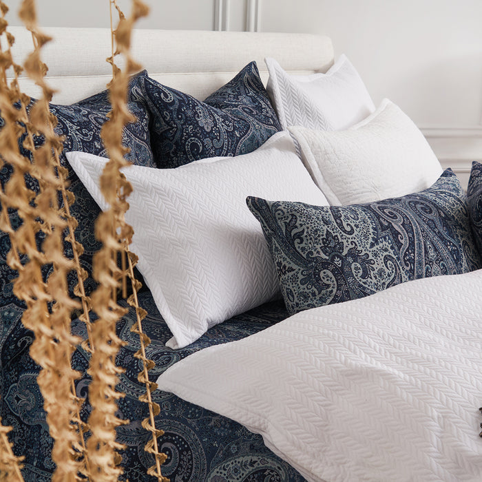 A Suman Coverlet displayed on a bed.