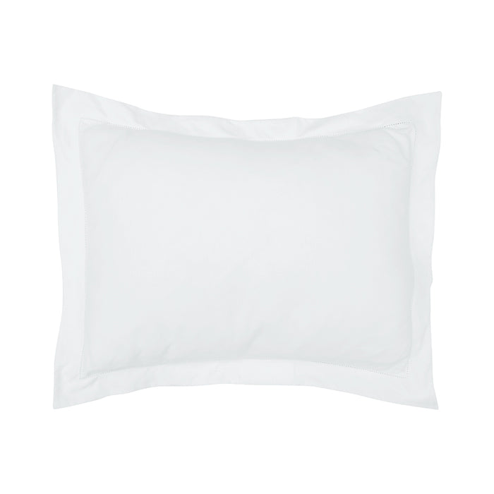 A standard-size pillow covered in a crisp white cotton sham with hemstitching.